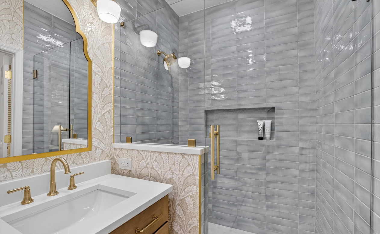 Bathroom remodel in Westchase, FL with custom tile walk in shower, wallpaper, modern vanity and gold hardware