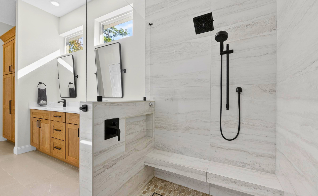 luxury bathroom remodel with aging in place doorless walk-in shower, with a bench, handheld shower, and towel hook in Lutz, FL