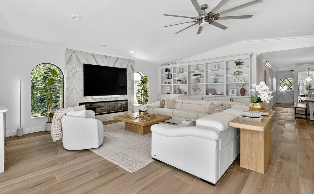 Living room with custom fireplace, area rug and built in shelving and cabinetry done by Hanover Floors