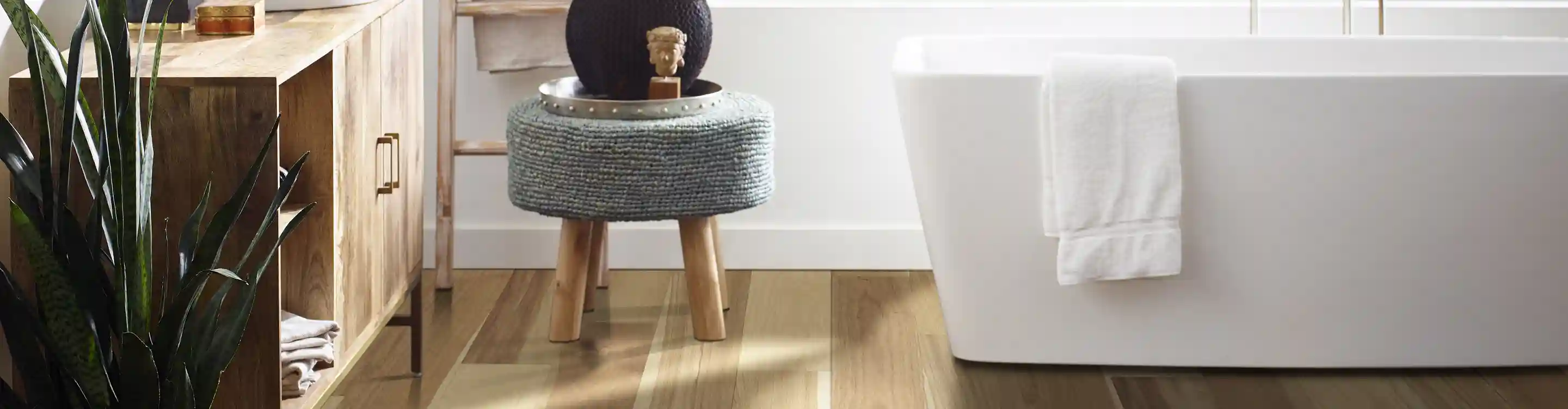 bathroom with white tub and wood floor