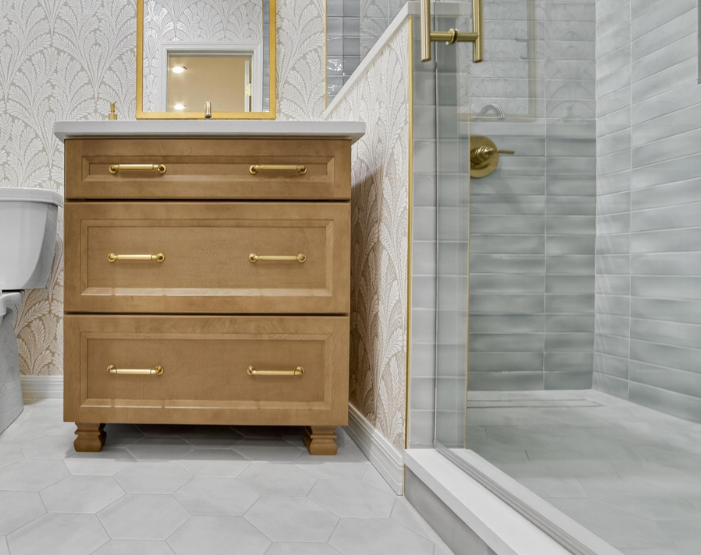 Luxurious remodeled bathroom with gray hexagonal tile flooring and custom tiled shower with glass door