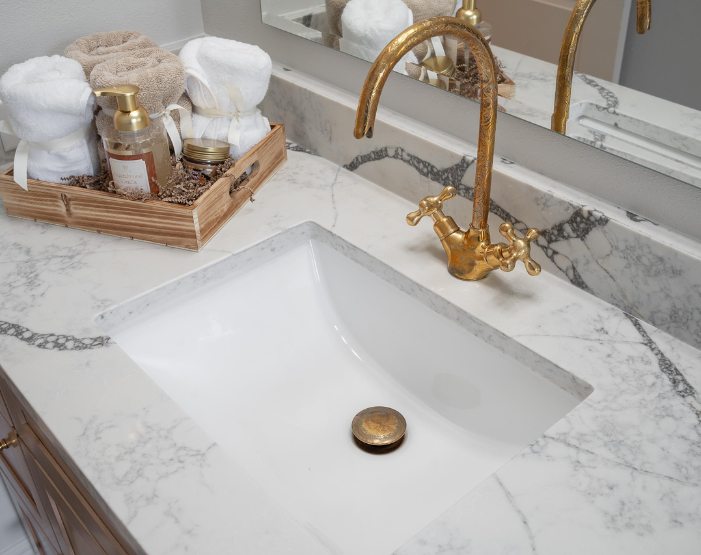 gold faucet and hardware on a vanity with marble countertops in Tampa, FL