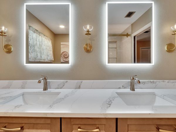 tampa bath remodel with double vanity sinks and backlit mirrors